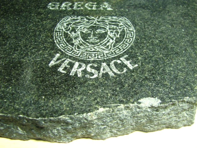 Logotip, graviran na surov temen granit