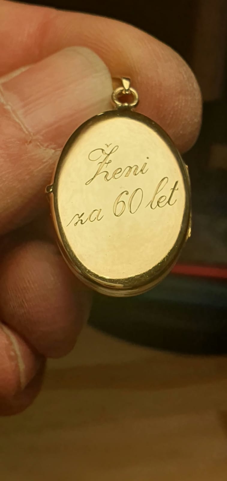Ovalen zlat medaljon z ročno vpisanim posvetilom.