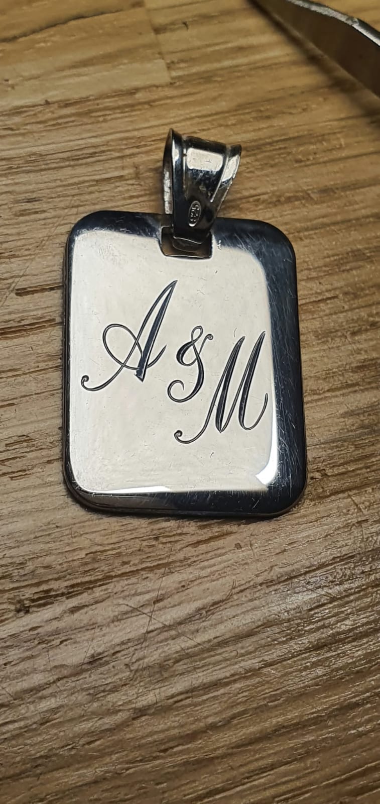 Pravokoten srebrn obesek z ročno graviranim monogramom.