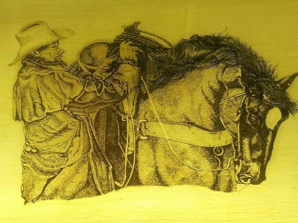 Ročna gravura jezdeca ob konju na kovinski plošči.
