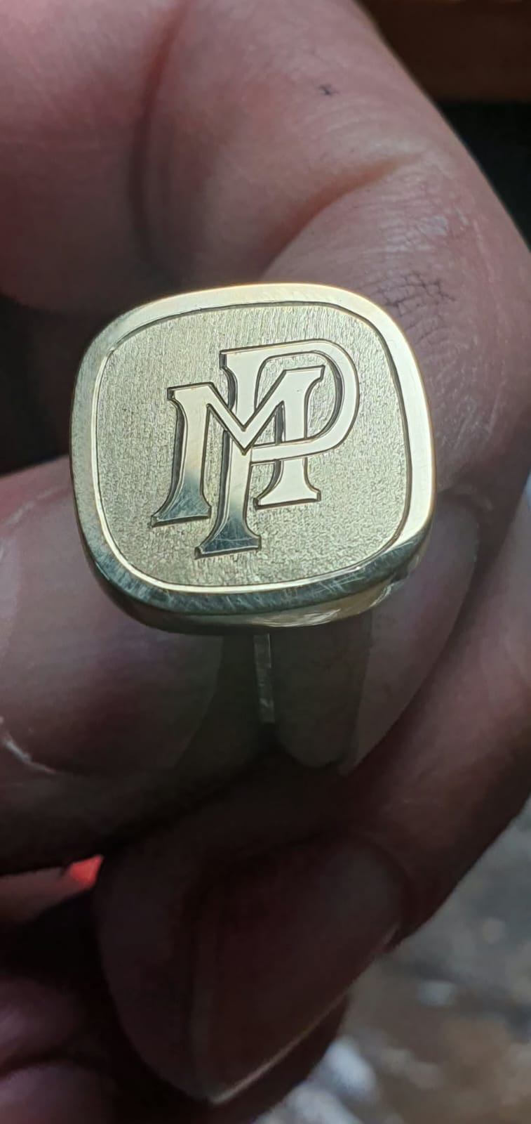 Zlat pečatni prstan z vgraviranima prepletenima začetnicama.